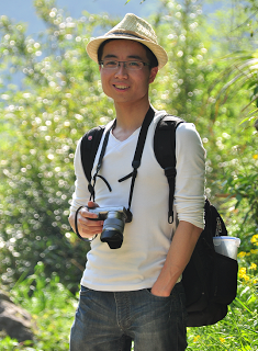 Dr. Kai Pan, camera in hand, poses for an outdoor photo