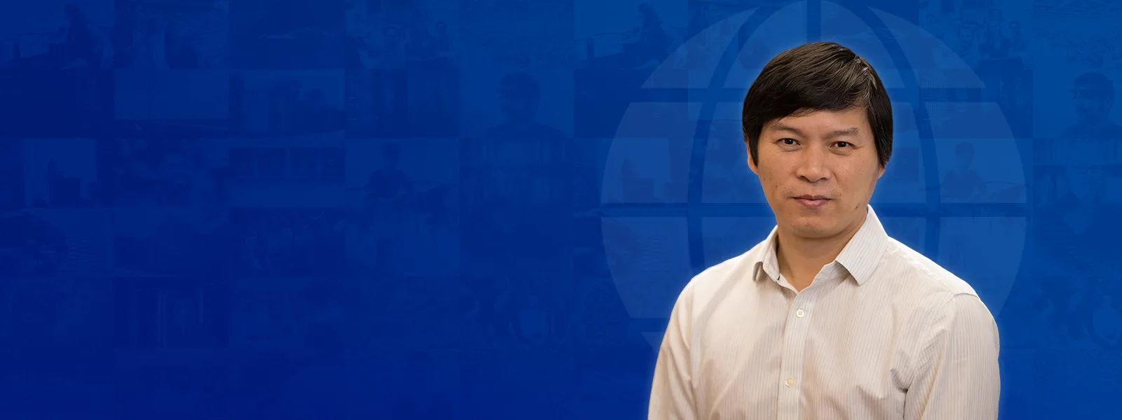 A man with short dark hair wearing a white button-down shirt against a blue background with a faint globe graphic.